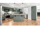 Well-lit kitchen with updated appliances, custom sage cabinets, hardwood floors, and a center island at 4906 S Crystal St, Aurora, CO 80015