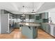 Well-lit kitchen with stainless steel appliances, an island and ample cabinet storage space at 4906 S Crystal St, Aurora, CO 80015