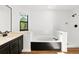 Bright main bathroom with soaking tub, black fixtures and lots of natural light at 4906 S Crystal St, Aurora, CO 80015