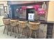 Rustic home bar featuring wooden stools, counter, vintage decor, and lighting, creating a unique entertaining space at 5740 S Delaware St, Littleton, CO 80120