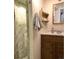Bathroom with a stand up shower, wooden vanity, and updated mirror at 5740 S Delaware St, Littleton, CO 80120