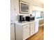 Charming kitchen featuring bright countertop, white cabinets, and hardwood floors at 5740 S Delaware St, Littleton, CO 80120