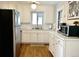 Bright kitchen featuring updated stainless steel appliances, white cabinets, and hardwood floors at 5740 S Delaware St, Littleton, CO 80120
