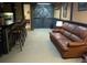 Spacious living area with a rustic bar, comfortable leather sofa, and warm lighting creating a welcoming atmosphere at 5740 S Delaware St, Littleton, CO 80120