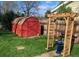 Red barn-style shed in a fenced backyard, complemented by a decorative arbor and a lush lawn at 5740 S Delaware St, Littleton, CO 80120