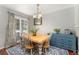 Bright dining room with wood floors, stylish light fixture, and large windows at 1385 W 112Th Ave # D, Denver, CO 80234