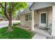 A welcoming front porch featuring a well-kept lawn, mature trees, and a charming entrance at 1385 W 112Th Ave # D, Denver, CO 80234