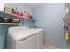 Functional laundry room with washer, dryer, and shelving for storage at 1385 W 112Th Ave # D, Denver, CO 80234