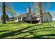 Backyard of home with a stone chimney, deck with patio furniture, and sprawling lush green lawn at 16440 Old Denver Rd, Monument, CO 80132