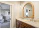 Bright bathroom featuring a double vanity with marble countertop and a wood-trimmed arched mirror at 16440 Old Denver Rd, Monument, CO 80132