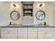 Bathroom with dual sinks, custom mirrors, a gray vanity, and bright lighting at 16440 Old Denver Rd, Monument, CO 80132