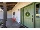 Inviting front porch featuring a green door, classic lanterns, and comfortable seating for relaxing outdoors at 16440 Old Denver Rd, Monument, CO 80132