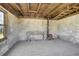 Rustic interior with a wood-burning stove, concrete walls, wood floors, and exposed beams adding to the room's charm at 16440 Old Denver Rd, Monument, CO 80132