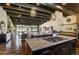 Spacious kitchen with granite counters, a gas cooktop island, pendant lighting, and exposed beam ceiling at 16440 Old Denver Rd, Monument, CO 80132