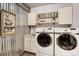 Well-organized laundry room with modern washer and dryer, upper cabinets, and a utility sink at 16440 Old Denver Rd, Monument, CO 80132