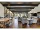 Spacious living room with hardwood floors, exposed beams, stone fireplace, and large windows offering picturesque views at 16440 Old Denver Rd, Monument, CO 80132