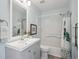 Bright bathroom featuring a tub shower combo, white tile, and a gray vanity with a modern sink at 2533 Central Park Blvd, Denver, CO 80238