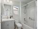 Bright bathroom featuring a tub shower combo, white tile, and a gray vanity with a modern sink and hardware at 2533 Central Park Blvd, Denver, CO 80238
