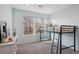 Bright bedroom featuring a loft bed, plush carpet, large windows, and a white dresser at 2533 Central Park Blvd, Denver, CO 80238