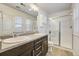 Bathroom features double sinks, vanity with storage, and a tiled shower with glass door at 3386 Valentia St, Denver, CO 80238