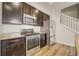 Well-equipped kitchen with stainless steel appliances, granite countertops, ample cabinet space, and easy access to the staircase at 3386 Valentia St, Denver, CO 80238