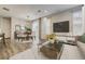 Bright living room features a modern TV console, neutral color palette, and elegant dining area with a decorative chandelier at 3386 Valentia St, Denver, CO 80238