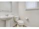 Convenient powder room with pedestal sink, toilet, and window at 3386 Valentia St, Denver, CO 80238