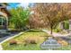 View of the street with address sign, manicured grass and mature trees at 3386 Valentia St, Denver, CO 80238