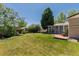 Expansive backyard featuring a lush lawn, mature trees, and a charming patio, perfect for outdoor relaxation and entertainment at 1229 W 102Nd Ave, Northglenn, CO 80260