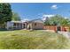 Expansive backyard featuring lush green grass, wooden fence, and mature trees at 1229 W 102Nd Ave, Northglenn, CO 80260