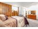 Bedroom with wood paneling, bed, and a dresser with large mirror at 1229 W 102Nd Ave, Northglenn, CO 80260