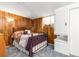 Cozy bedroom featuring wood paneling, carpet, and a comfortable bed at 1229 W 102Nd Ave, Northglenn, CO 80260