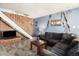 Spacious living room with brick accent wall and stairs at 7309 W Hampden Ave # 402, Lakewood, CO 80227