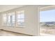 Bright, sunlit living room featuring light wood floors and large windows with neighborhood views and sliding glass door at 918 Congress Pl, Elizabeth, CO 80107