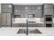 Modern kitchen featuring stainless steel appliances, gray cabinets, and a stylish sink and faucet at 3338 Ireland Moss St, Castle Rock, CO 80109