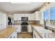 Well-lit kitchen with white cabinetry, stainless steel appliances, and granite countertops at 618 S Carlton St, Castle Rock, CO 80104