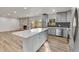 Spacious open-concept kitchen boasts stainless steel appliances, gray cabinetry, and quartz island at 5224 Scranton Ct, Denver, CO 80239