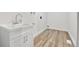 Bright laundry room features wood-look flooring and modern sink at 5224 Scranton Ct, Denver, CO 80239