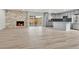 Spacious open-concept living area with modern fireplace, wood flooring, and stainless kitchen appliances at 5224 Scranton Ct, Denver, CO 80239