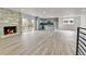 Spacious open-concept living area with modern fireplace, wood flooring, and stainless kitchen appliances at 5224 Scranton Ct, Denver, CO 80239