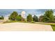 Community basketball court with hoop, surrounded by trees and open space on a cloudy day at 12790 Jackson St, Thornton, CO 80241
