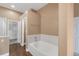 Bright bathroom featuring a soaking tub, walk-in closet and wood look flooring at 12790 Jackson St, Thornton, CO 80241