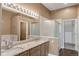 Bright, spacious primary bathroom with double sinks, granite counters, and wood-look floors at 12790 Jackson St, Thornton, CO 80241