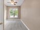 Bedroom with large window offering backyard view, complemented by a ceiling fan at 12790 Jackson St, Thornton, CO 80241
