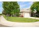 Charming stone home with a well-manicured front lawn, mature trees, and a two-car garage at 12790 Jackson St, Thornton, CO 80241