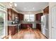 Modern kitchen with stainless steel appliances, granite counters, and warm wood flooring at 12790 Jackson St, Thornton, CO 80241
