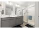 Bathroom with double sinks, gray cabinets, and glass-enclosed shower at 3074 Belleville Ridge Rd, Elizabeth, CO 80107