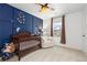 Bedroom with a crib, a comfortable chair, and dark blue accent wall at 3074 Belleville Ridge Rd, Elizabeth, CO 80107
