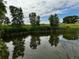 A scenic view of a pond reflecting trees and cloudy skies; calm water at 39633 E 160Th Ave, Keenesburg, CO 80643