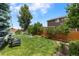 Serene backyard setting featuring a lush lawn, raised garden beds, and mature trees at 21885 Whirlaway Ave, Parker, CO 80138